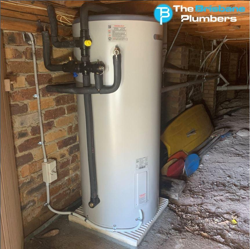 Electric hot water system installed under a house with insulated pipe connections and plumbing fittings