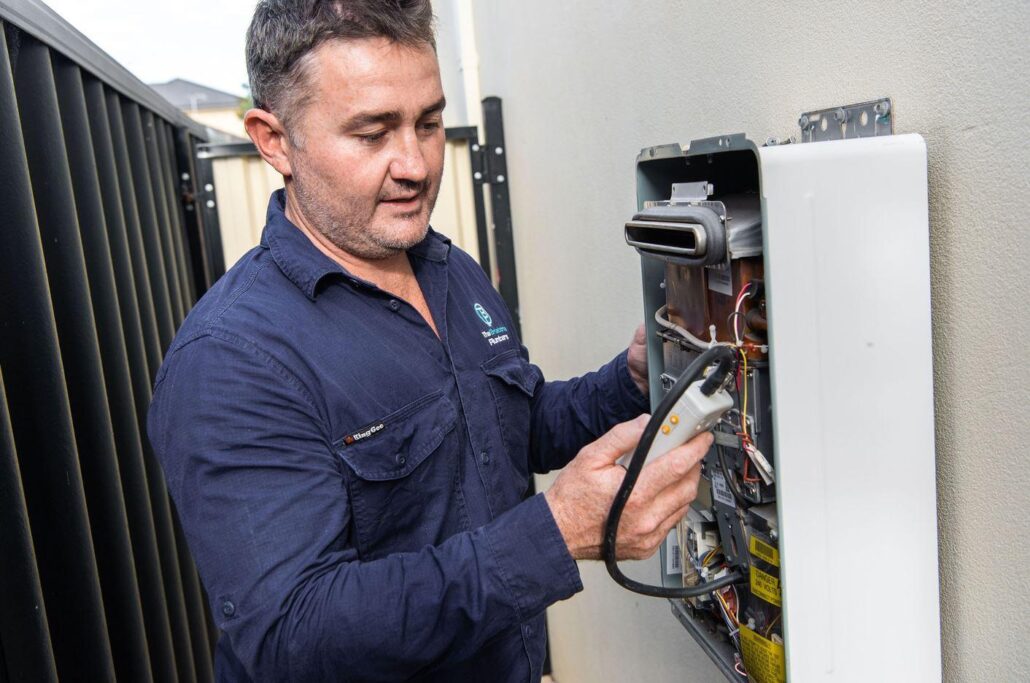 Joseph from The Brisbane Plumbers diagnosing the internal components of a gas hot water system in Brisbane