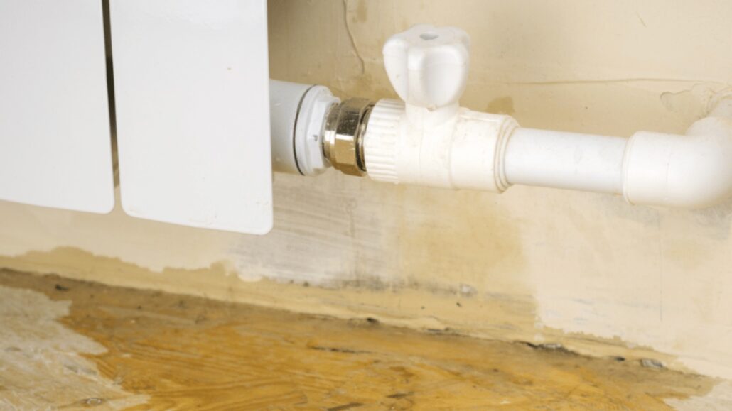 Close-up of a white radiator valve and connected plumbing pipe, indicating a heating system connection or installation.