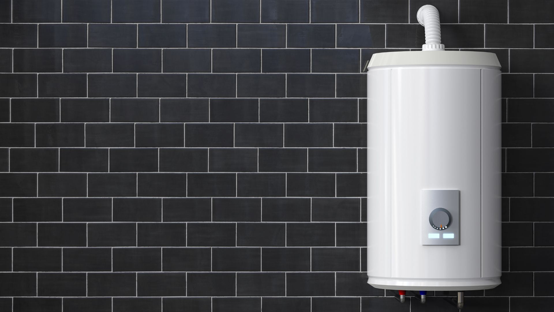 Modern white water heater installed on a dark tiled wall, with visible temperature controls and pipes.