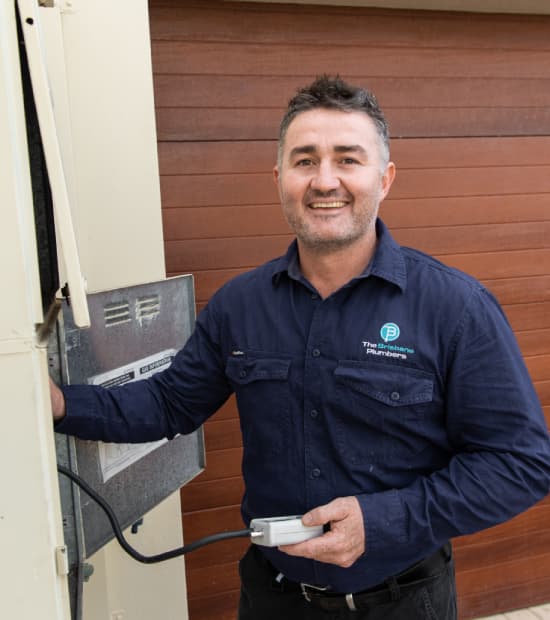 Joseph, Director of The Brisbane Plumbers, inspecting a hot water system at a Brisbane home