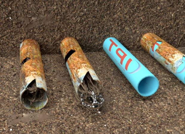 A close-up view of broken pipes in the ground, one of which is rusted and cracked, exposing roots inside, while the other is a new, blue PVC pipe.